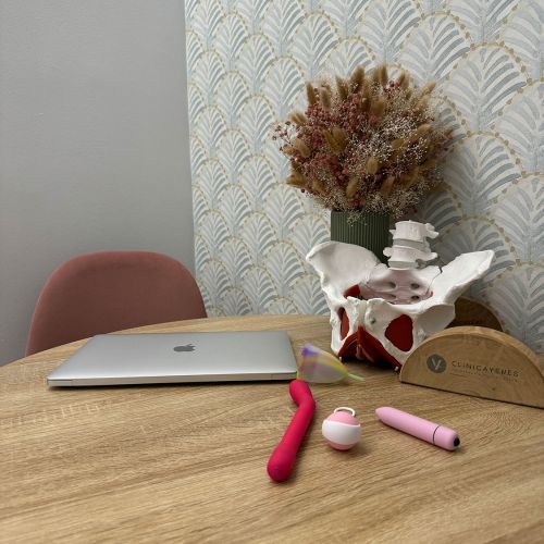 Detalle de figura de pelvis sobre mesa de madera en sala de espera